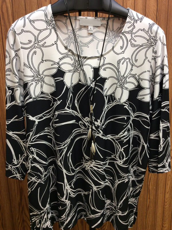 Dallas Tropical Reverse Print Top - Black and white multi floral print   Round neckline  3/4 sleeve  Vented sides  95% Poly 5% Spandex  Machine washable  Available 1X - 3X   (necklace sold separately)